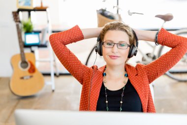 Kulaklıklar ile ofiste genç kadın