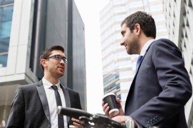 İki genç işadamları ile bir bisiklet şehir merkezinde