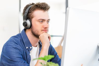 Genç adam ofiste çalışıyor.