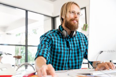 Genç adam ofiste çalışıyor.