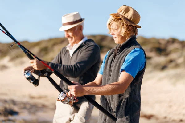 Uomo anziano pesca con suo nipote — Foto Stock