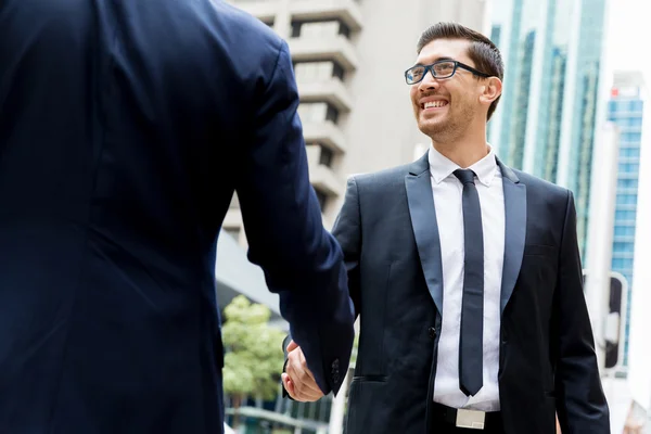 Dos hombres de negocios estrechando sus manos — Foto de Stock