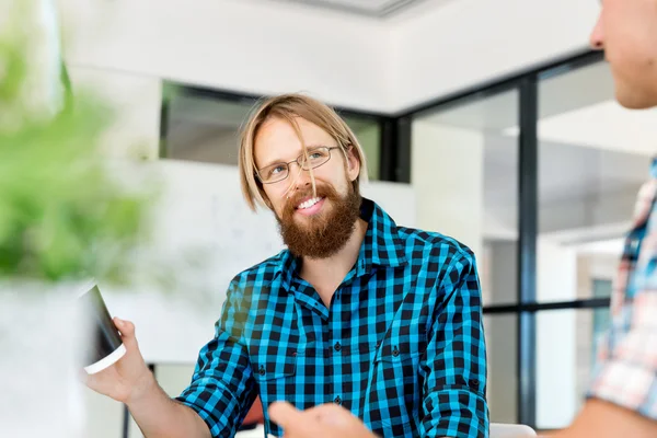 Jeune homme travaillant dans le bureau — Photo