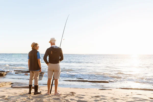 Uomo anziano pesca con suo nipote — Foto Stock