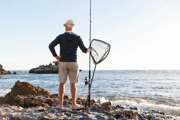 Hombre mayor pescando en el lado del mar — Foto de Stock