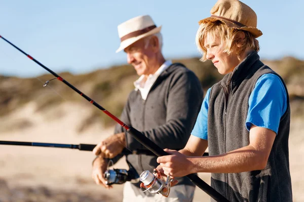 Senior man vissen met zijn kleinzoon — Stockfoto