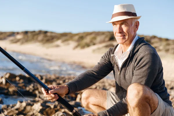 Senior mannen fiske till sjöss sida — Stockfoto