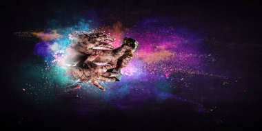 Elinde altın bir kupa var, arka planda.