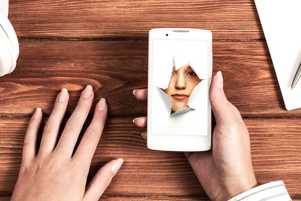 Female face through the hole in paper — Stock Photo, Image