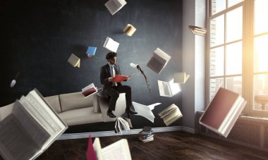Kitap okuyan genç bir adam. Karışık ortam