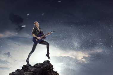 Genç ve güzel rock kızı elektro gitar çalıyor.