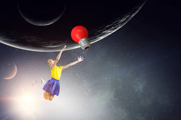 Chica flotando en el espacio con bombilla — Foto de Stock