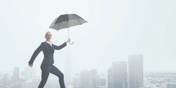 Jovem empresária caminhando com guarda-chuva — Fotografia de Stock