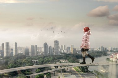 Arka planda şehirle yürüyen küçük kız