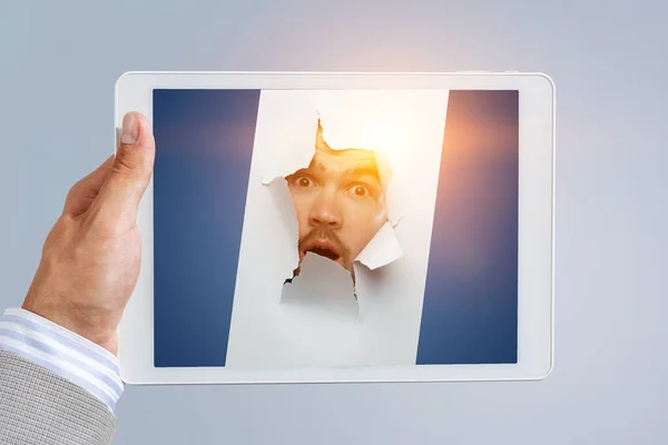 Male face through the hole in paper — Stock Photo, Image