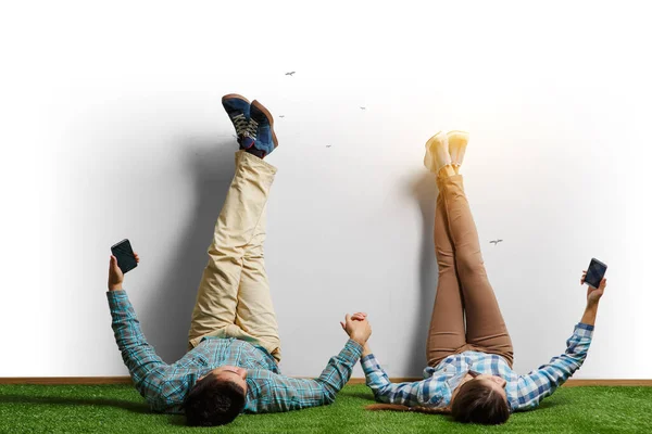 Casal relaxante com as pernas na parede — Fotografia de Stock