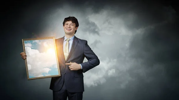 Man holding frame with blue sky and clouds — Stock Photo, Image