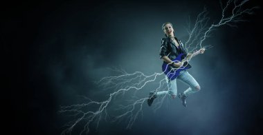 Genç ve güzel rock kızı elektro gitar çalıyor.