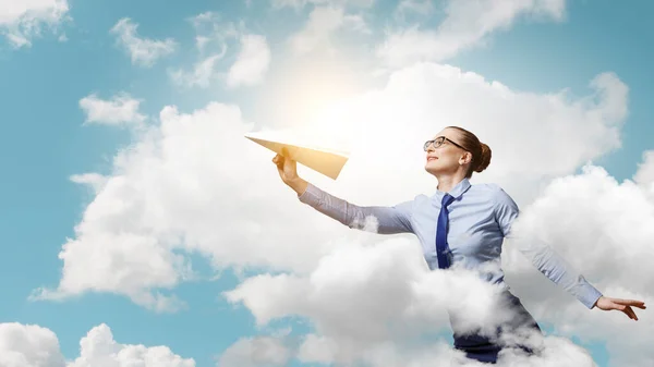 Young businesswoman holding a paper plane . Mixed media — Stock Photo, Image