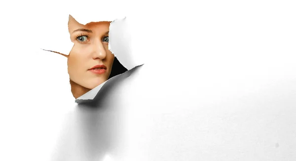 Woman looking out from a hole of torn paper — Stock Photo, Image