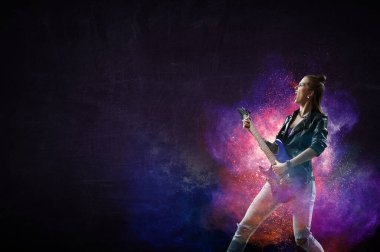 Genç ve güzel rock kızı elektro gitar çalıyor.