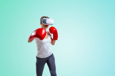 VR gözlüklü genç kadın boks yapıyor.