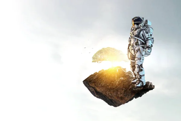 Astronauta contra el cielo nublado fondo —  Fotos de Stock