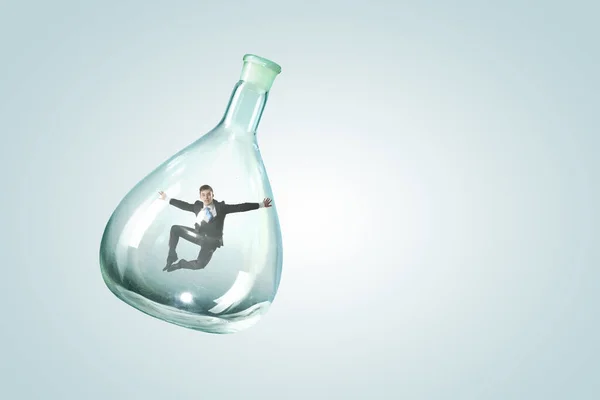 Jeune homme d'affaires dansant à l'intérieur bouteille en verre — Photo
