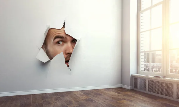 Männliches Gesicht durch das Loch in Papier — Stockfoto