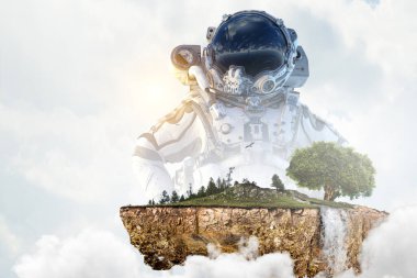 Bulutlu gökyüzü arkaplanına karşı astronot