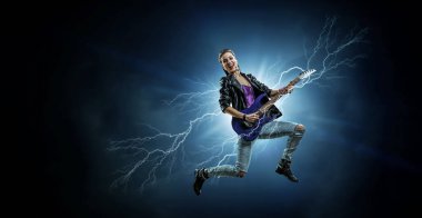 Elektro gitar çalan genç ve güzel bir rock kızı. Karışık ortam