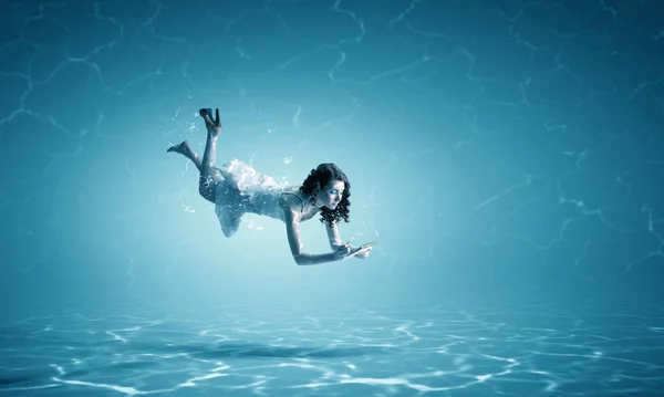 Žena držící šálek pod vodou — Stock fotografie