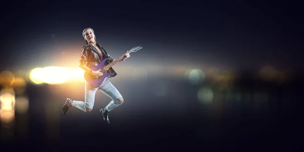 Menina de rock jovem e bonita tocando a guitarra elétrica. Meios mistos — Fotografia de Stock