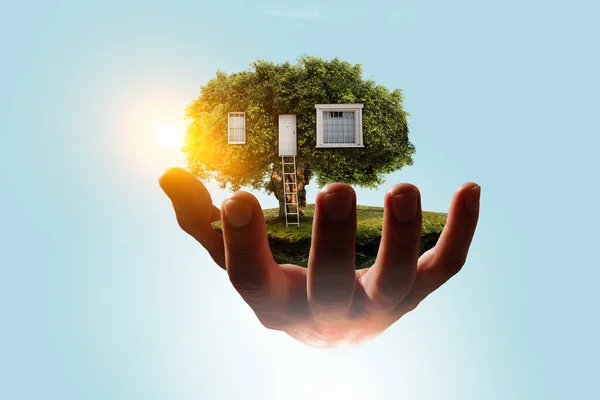 Ręka trzyma zielony dom. Media mieszane — Zdjęcie stockowe