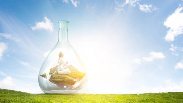 Business woman doing yoga in lotus pose inside glass bottle — Stock Photo, Image