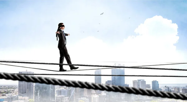 Imagen del hombre de negocios balanceándose en la cuerda. Concepto de riesgo. Medios mixtos —  Fotos de Stock