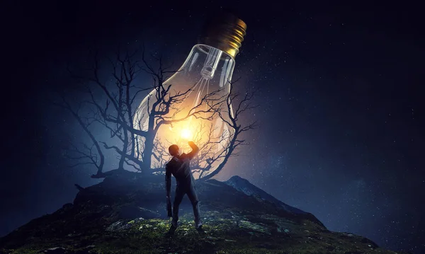 Huge light bulb glowing in the darkness — Stock Photo, Image