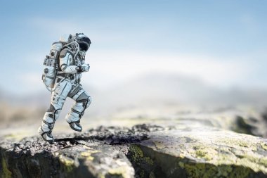 Keşfedilmemiş bir gezegende yürüyen astronot