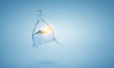 Cam şişeden su fışkırıyor.