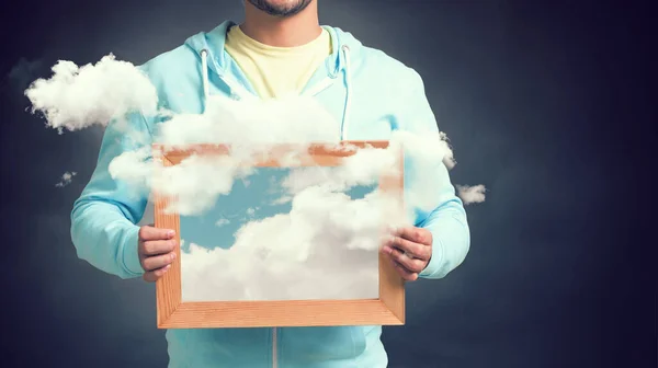 Muž držící rám s modrou oblohou a mraky — Stock fotografie
