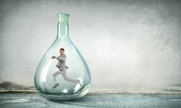 Young businessman dancing inside glass bottle — Stock Photo, Image