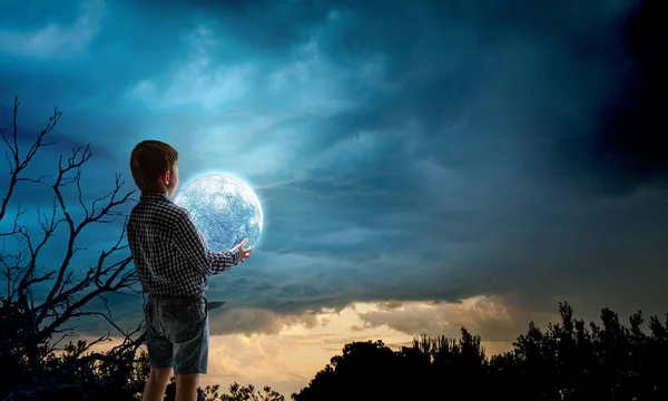 Pojke som håller månen på natten — Stockfoto