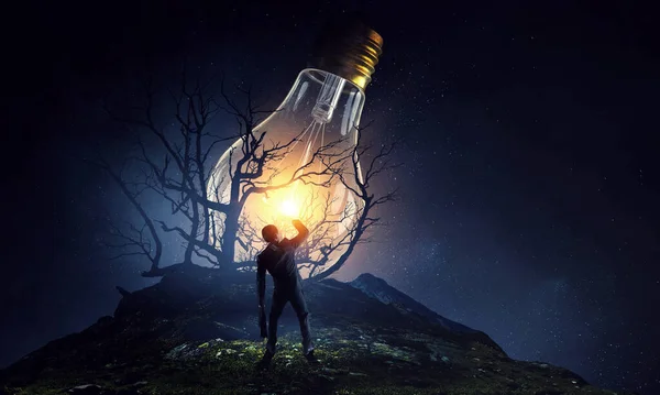 Huge light bulb glowing in the darkness — Stock Photo, Image