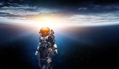 Keşfedilmemiş bir gezegende yürüyen astronot. Karışık ortam