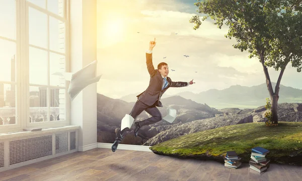 Happy businessman jumping high . Mixed media — Stock Photo, Image