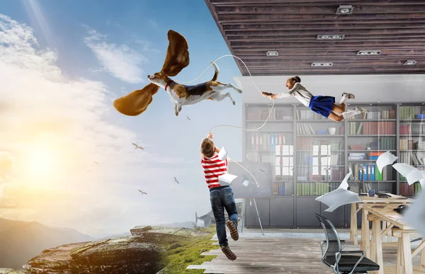 A fiú egy kutyával a fülével repül a levegőben. — Stock Fotó