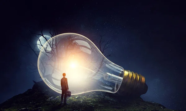 Huge light bulb glowing in the darkness — Stock Photo, Image