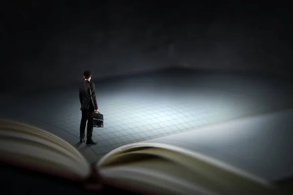 Young businessman standing on a huge book — Zdjęcie stockowe