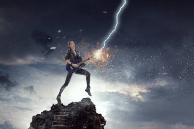 Elektro gitar çalan genç ve güzel bir rock kızı. Karışık ortam