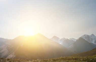Dağlarla çevrili bir manzara. Karışık ortam